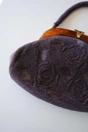 Detailed view of intricate Japanese glass seed bead and bugle bead embroidery on vintage purple handbag