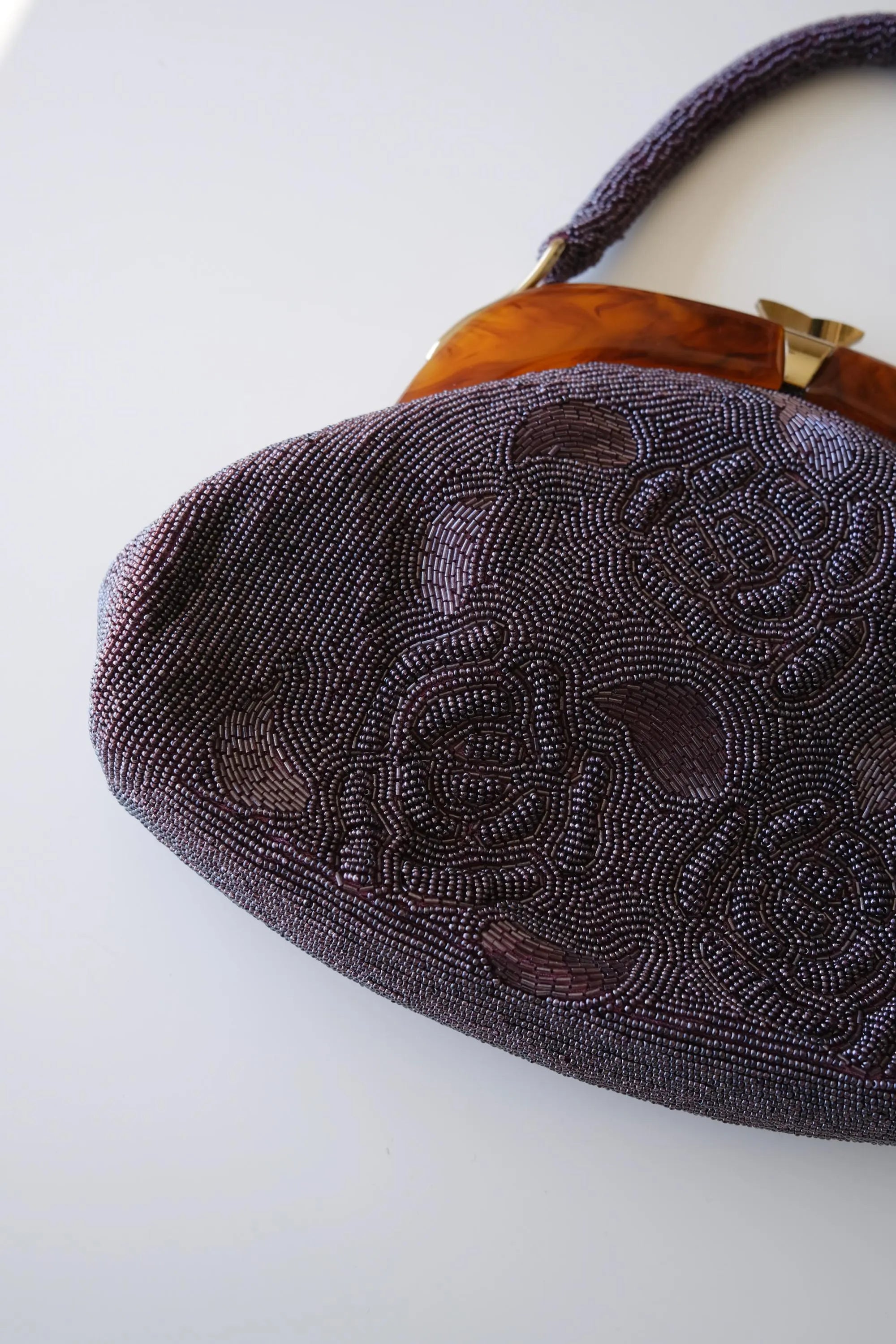 Detailed view of intricate Japanese glass seed bead and bugle bead embroidery on vintage purple handbag