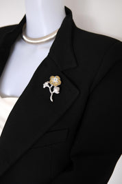 KENZO vintage silver and champagne gold floral brooch with blue crystal accents worn on a coat