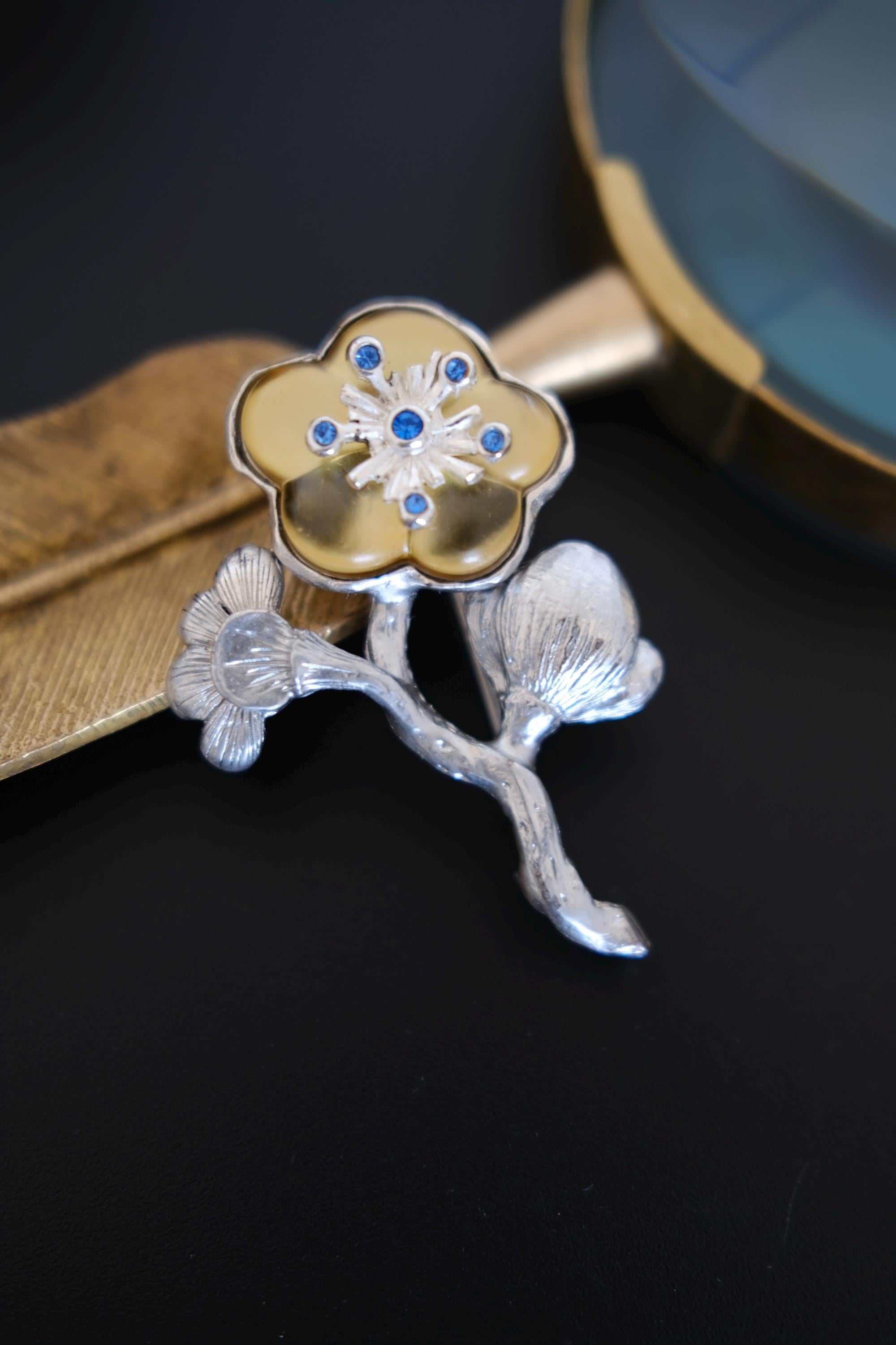 Vintage KENZO flower brooch with blue crystals, champagne gold floral detail and sculptural silver tone leaves, made in France