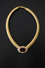 Vintage Nina Ricci gold-tone Tubogas collar necklace with large faceted ruby-red glass centerpiece and clear crystal accents