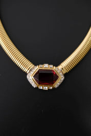 Detailed view of sparkling clear crystals surrounding the ruby-red glass centerpiece of vintage Nina Ricci necklace
