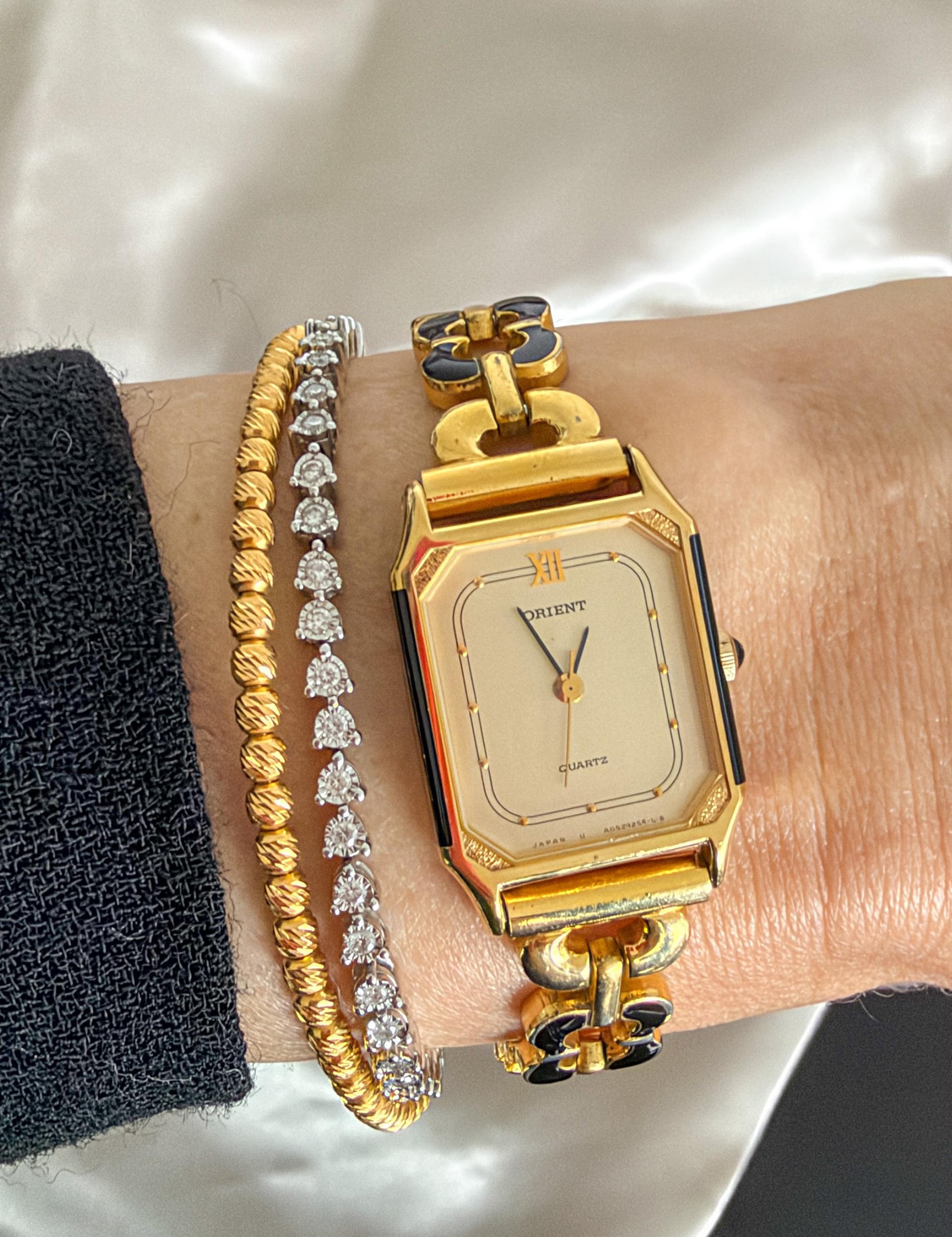 Vintage ORIENT gold plated ladies quartz bracelet watch with black enamel floral links and rectangular case