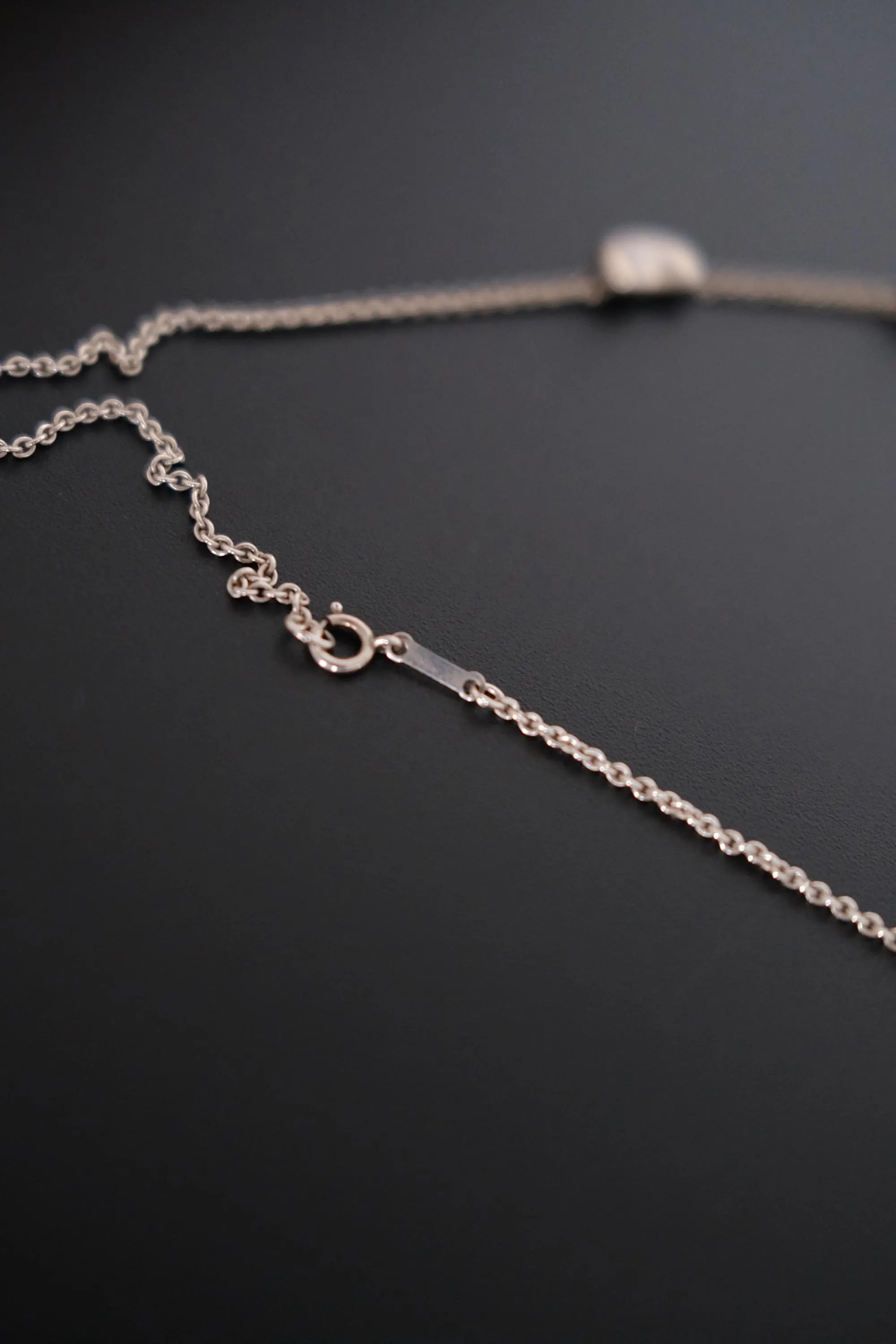 Close-up of delicate sterling silver chain connecting the five Bean motifs on vintage Tiffany & Co necklace