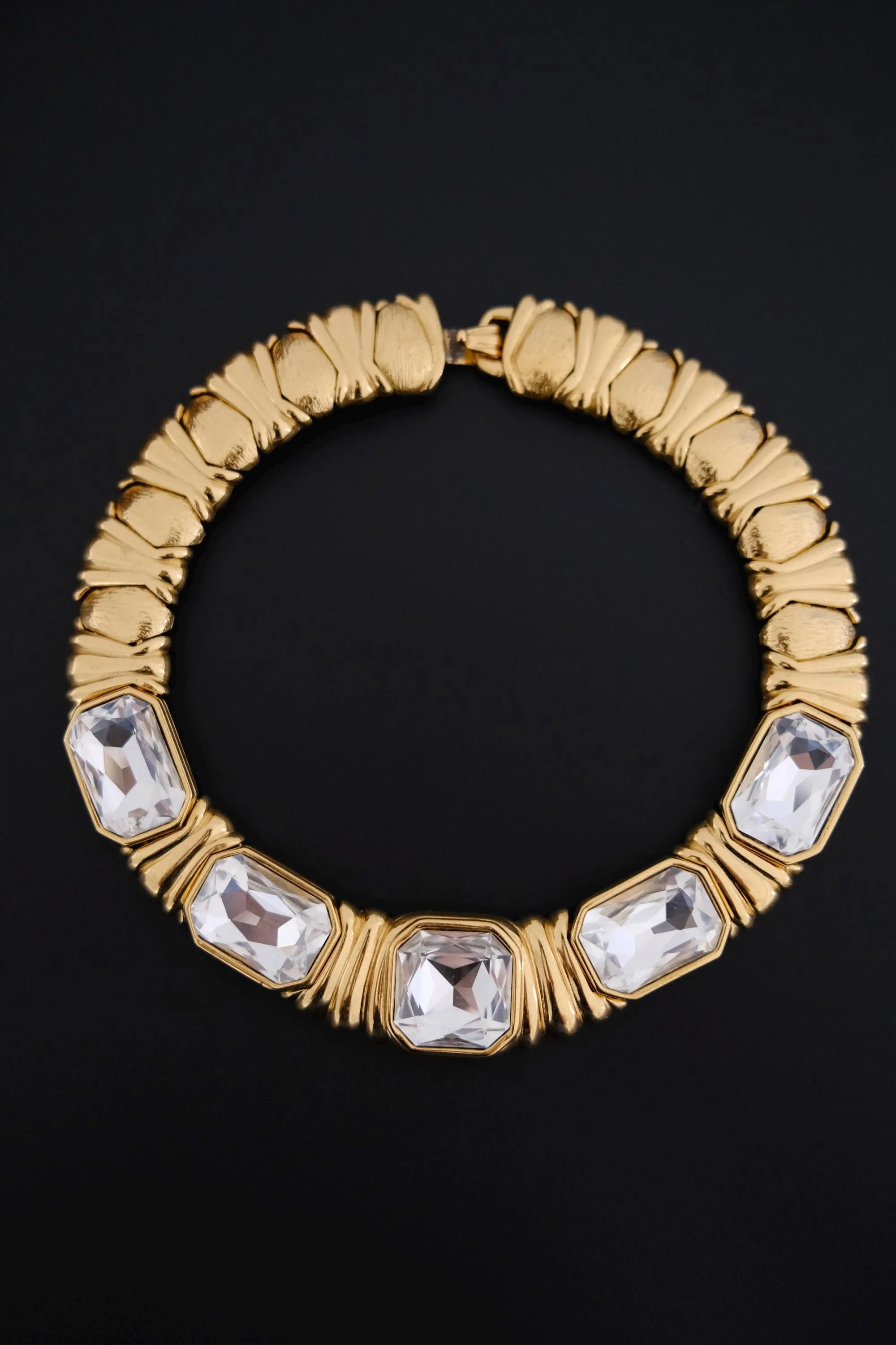 Full view of vintage YSL sculptural gold-tone collar necklace featuring five large clear crystals and architectural ribbed details