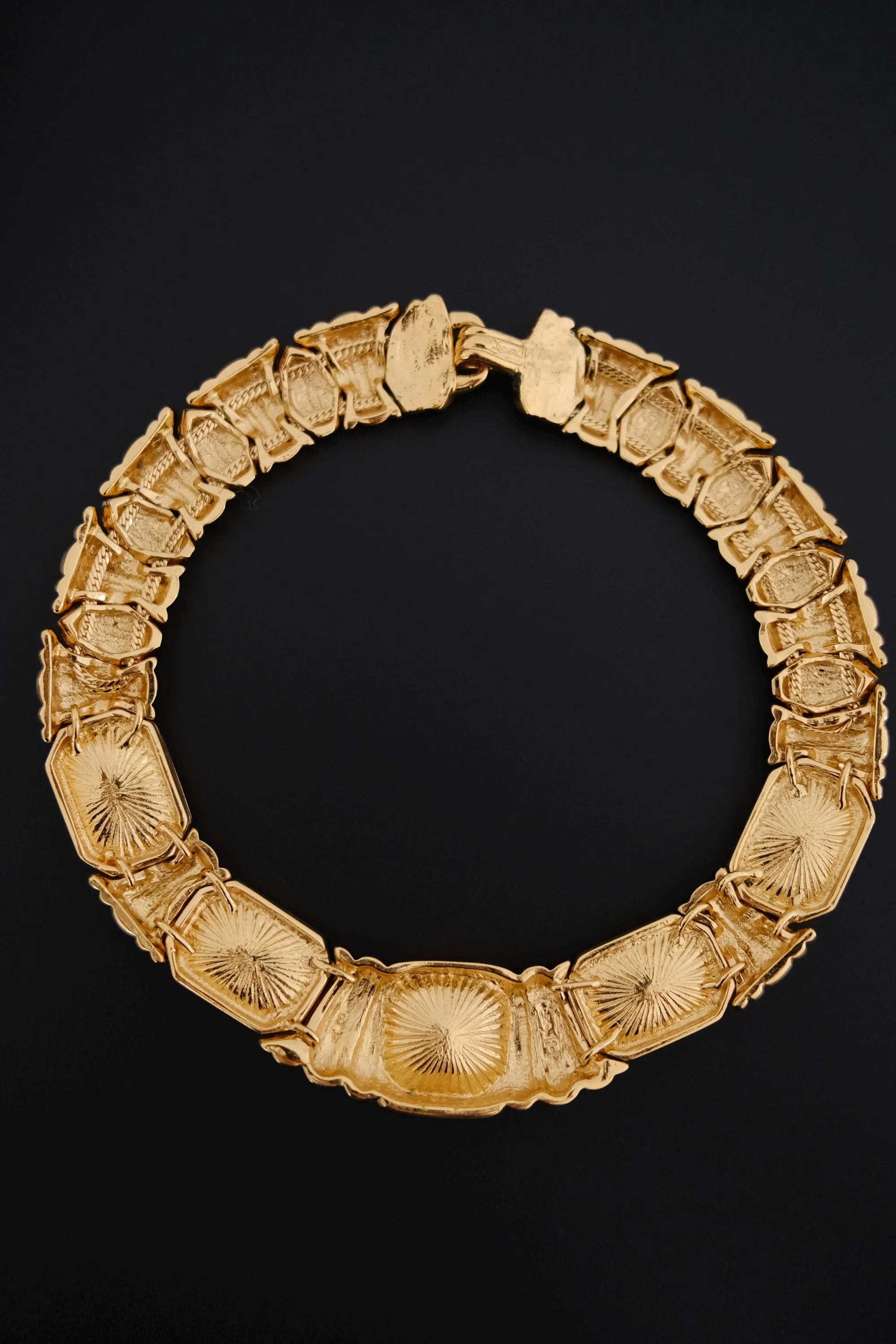 Back view of vintage Yves Saint Laurent gold-tone crystal collar necklace showing curved construction and closure