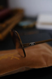 Close-up of YSL logo plaque and decorative multi line hinge detailing on vintage Yves Saint Laurent sunglasses