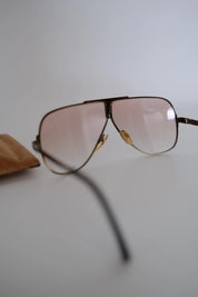 Side view of vintage Yves Saint Laurent aviator sunglasses showing decorative temple hinges and metal frame construction