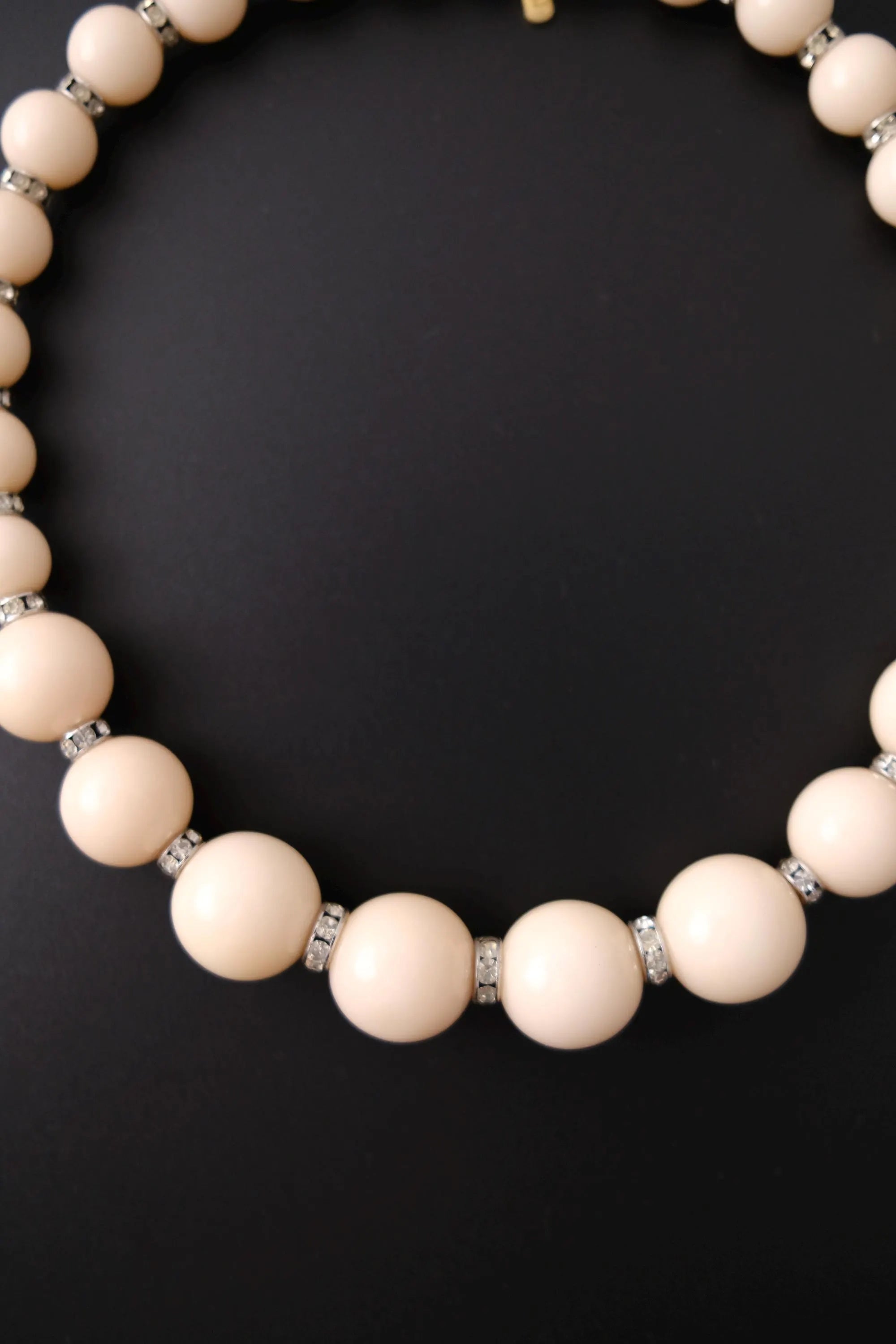 Close-up of smooth glossy beige cream beads on vintage Yves Saint Laurent choker necklace