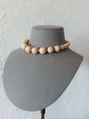 Vintage Yves Saint Laurent beige graduated bead choker necklace worn elegantly around the neckline