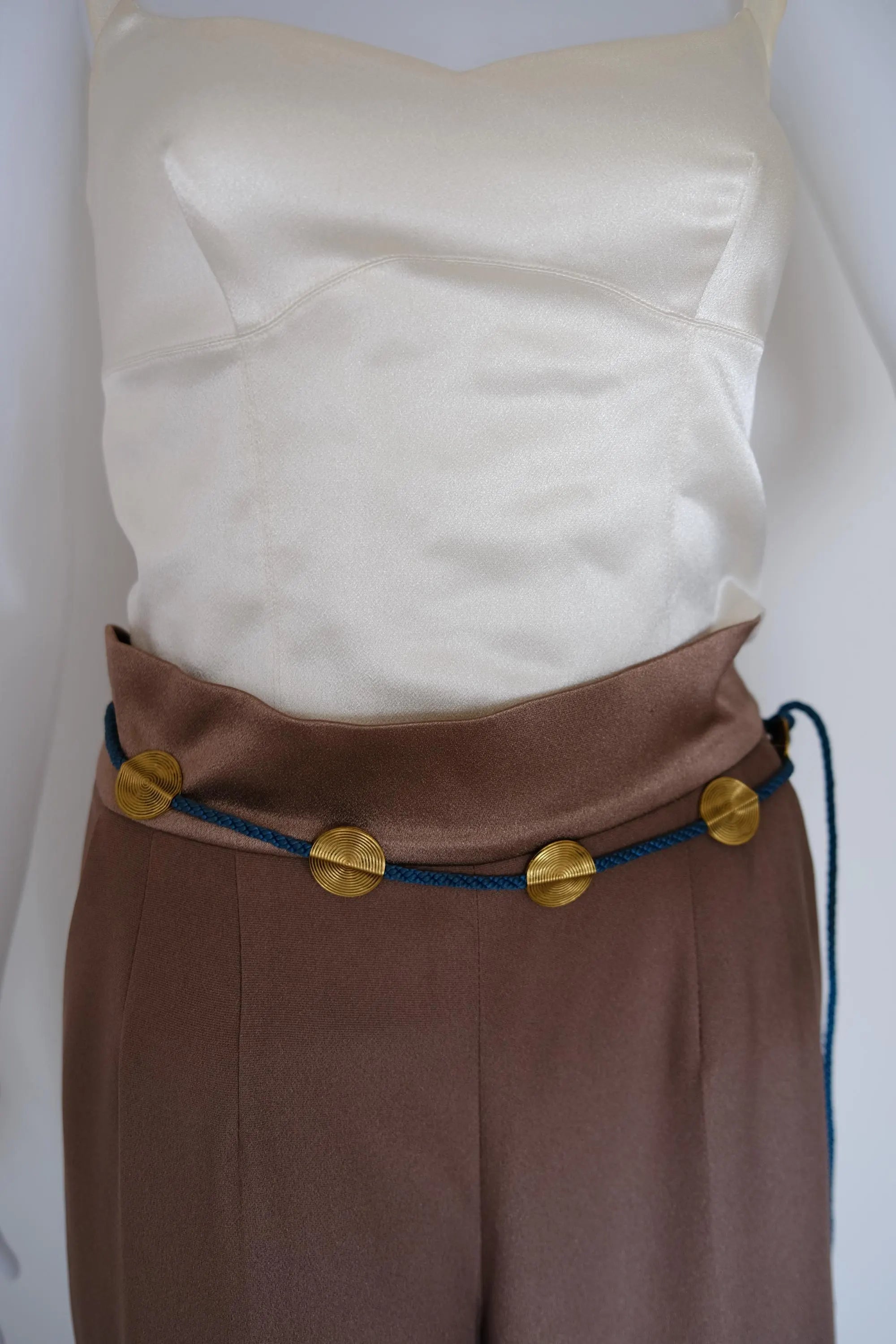 Vintage YSL blue braided cord medallion belt styled around the waist with gold-tone accents