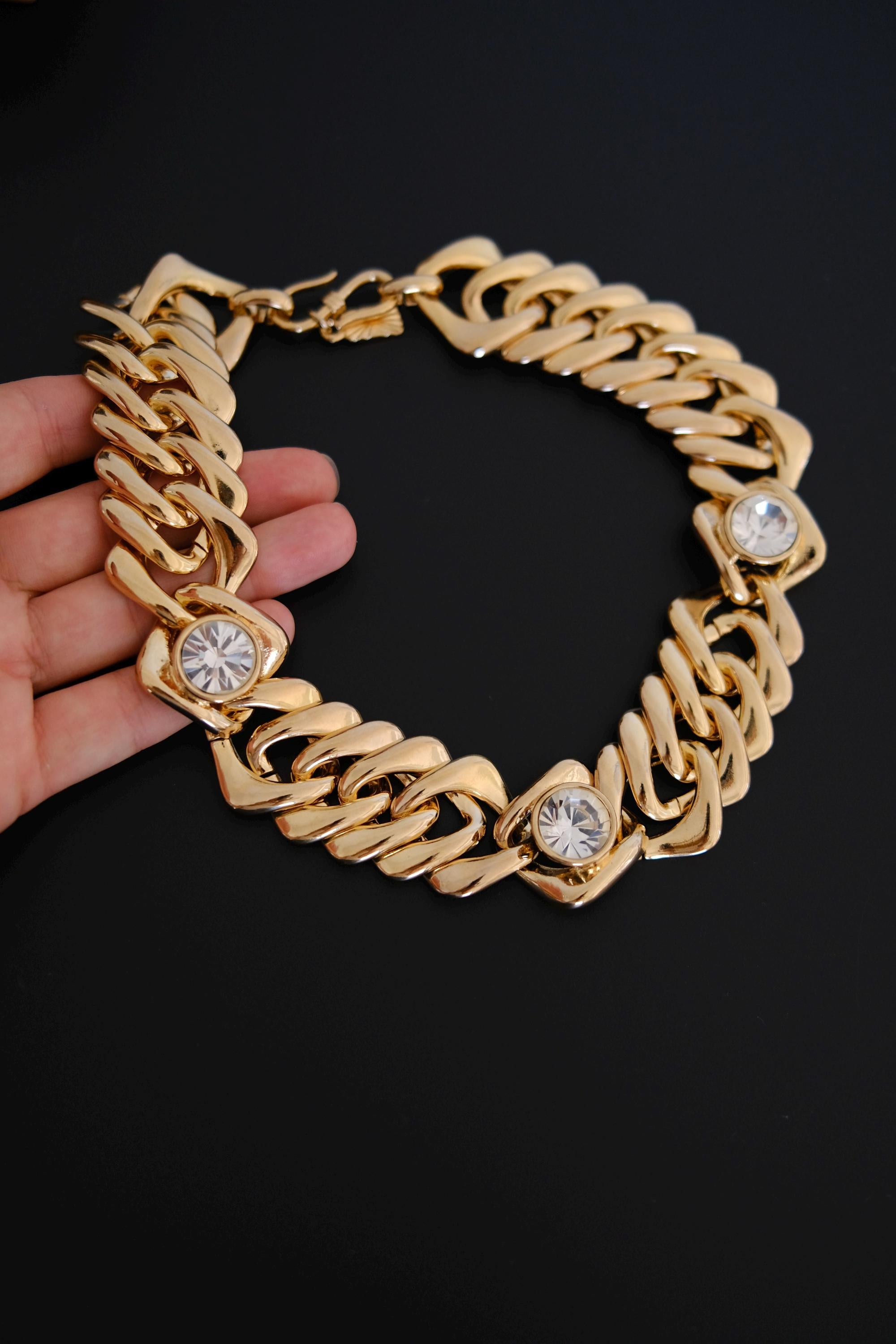 Detailed view of bright gold-tone finish and sparkling clear crystals on vintage YSL necklace in excellent vintage condition
