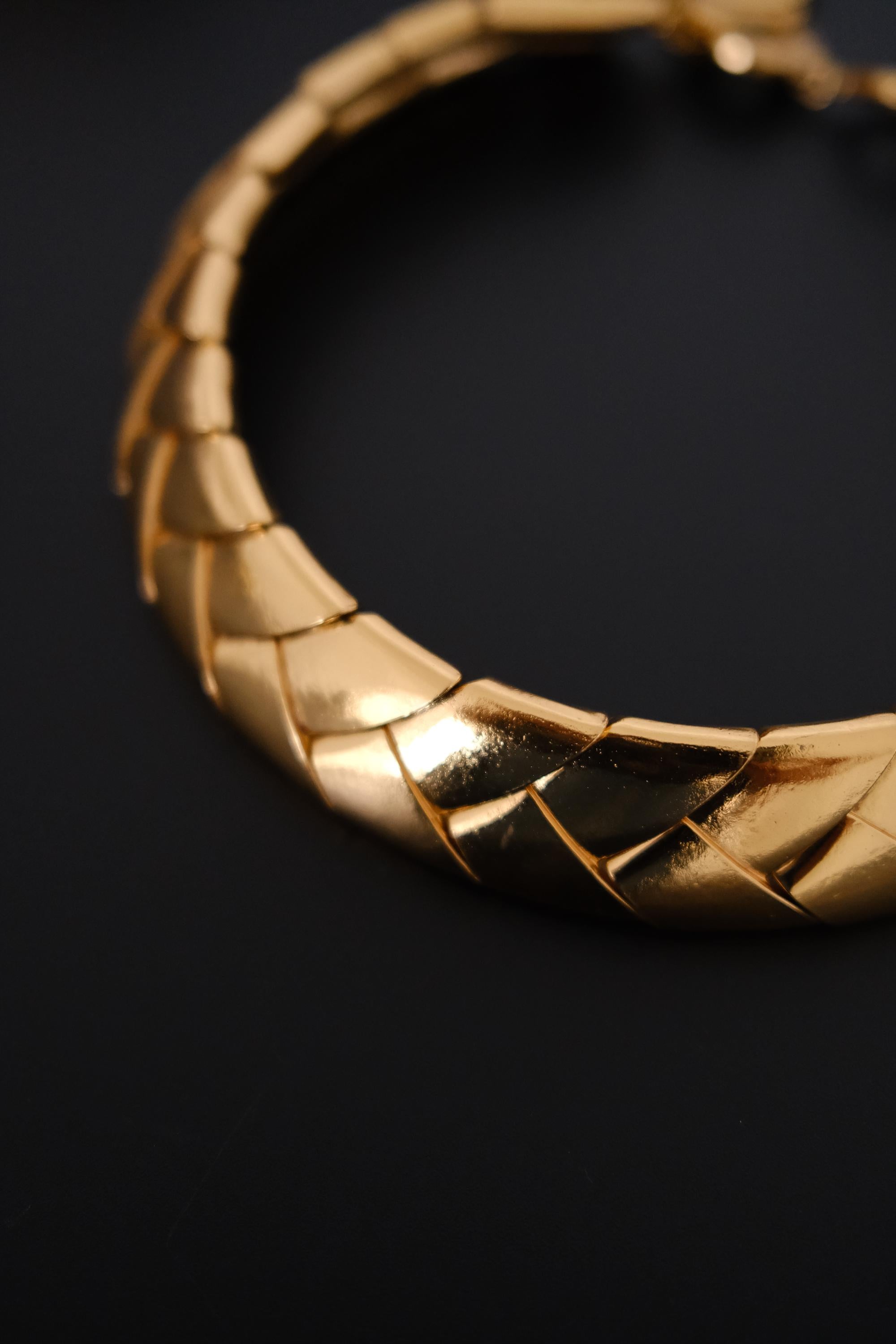 Close-up of overlapping sculptural wheat style gold tone links on vintage Yves Saint Laurent choker necklace