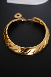 Full view of vintage Yves Saint Laurent gold tone choker necklace featuring overlapping articulated wheat inspired links