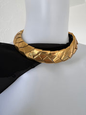 Vintage Yves Saint Laurent gold statement choker necklace worn around the neckline showing bold sculptural wheat style links