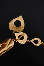 Close-up of YVES SAINT LAURENT signature engraved on heart shaped closure elements of vintage gold necklace