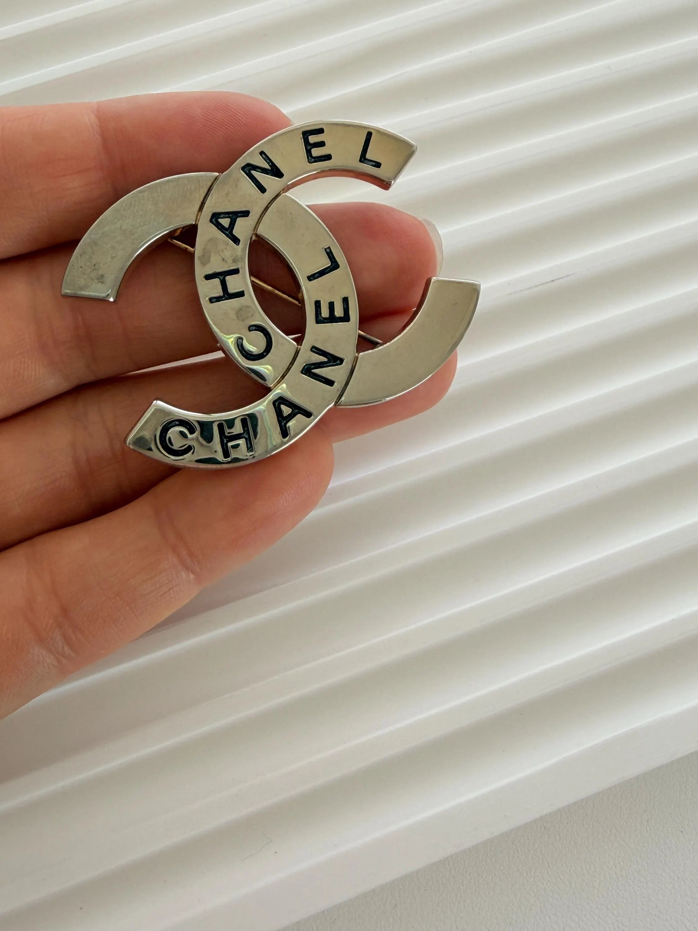 Authentic Chanel vintage CC brooch with light patina and elegant shine