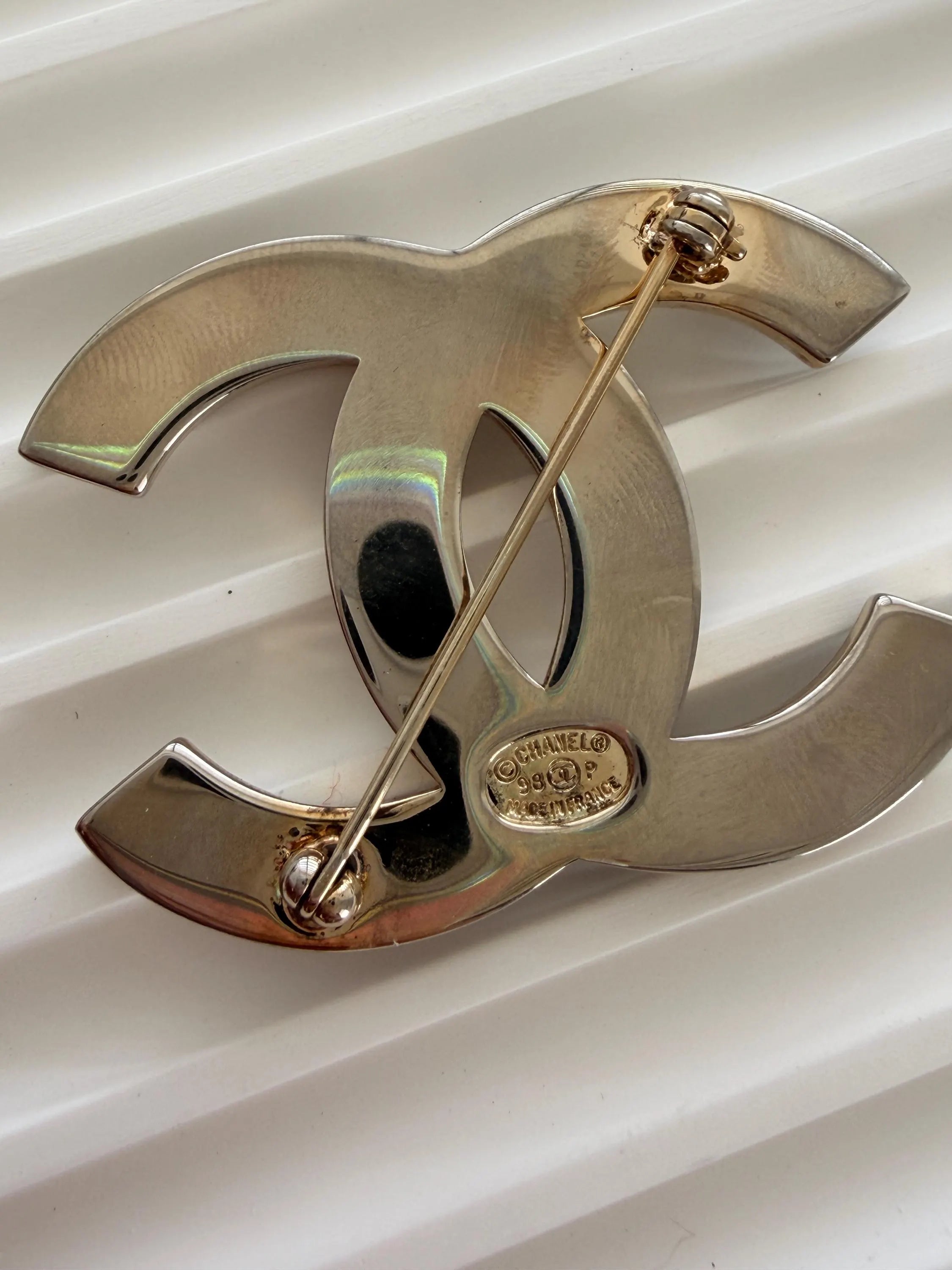 Authentic Chanel vintage CC brooch with light patina and elegant shine