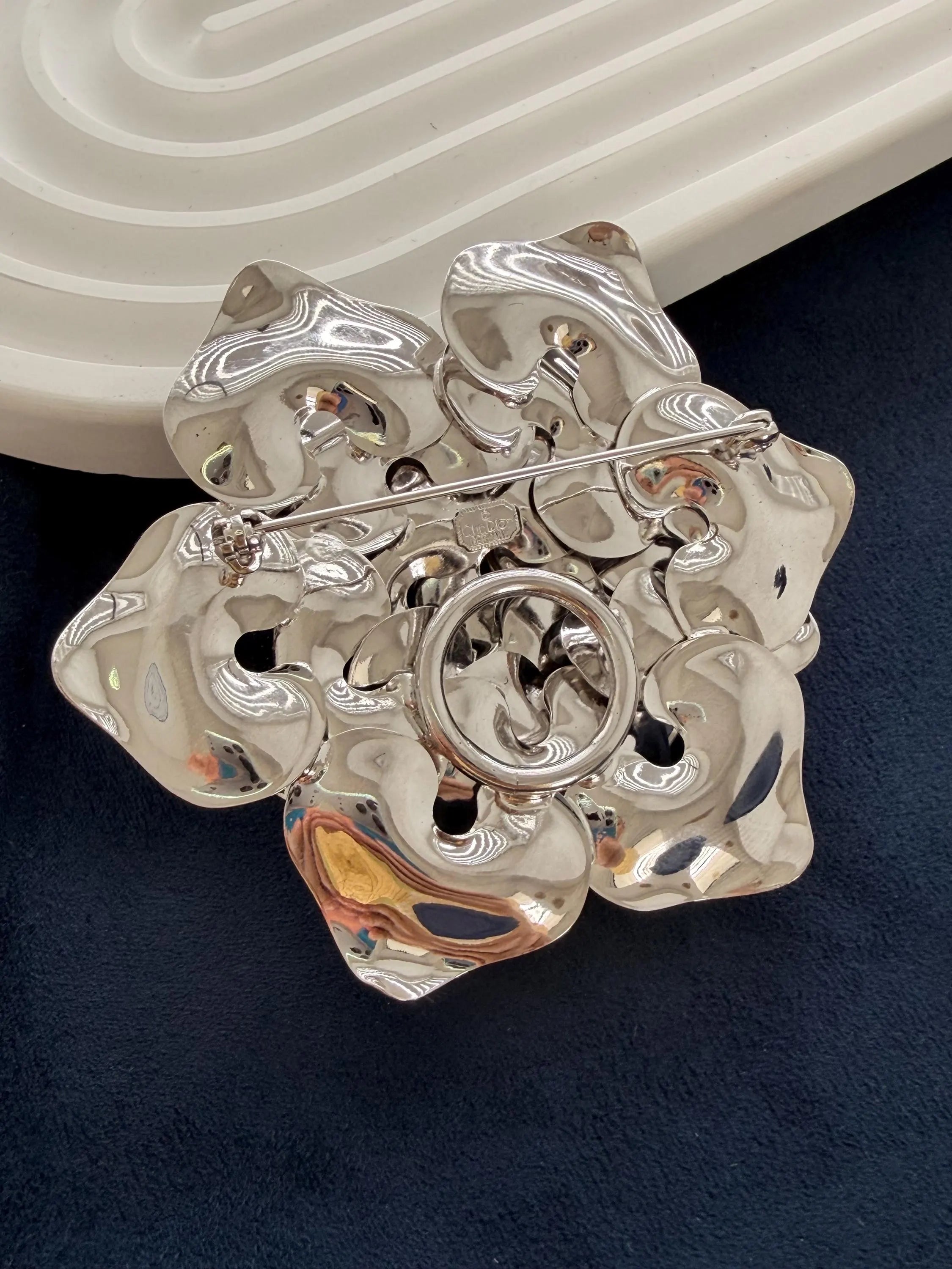 Close-up of layered petals on vintage Dior rose brooch high polish finish
