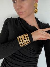 Vintage Givenchy chunky gold tone G logo bracelet worn as bold statement jewelry