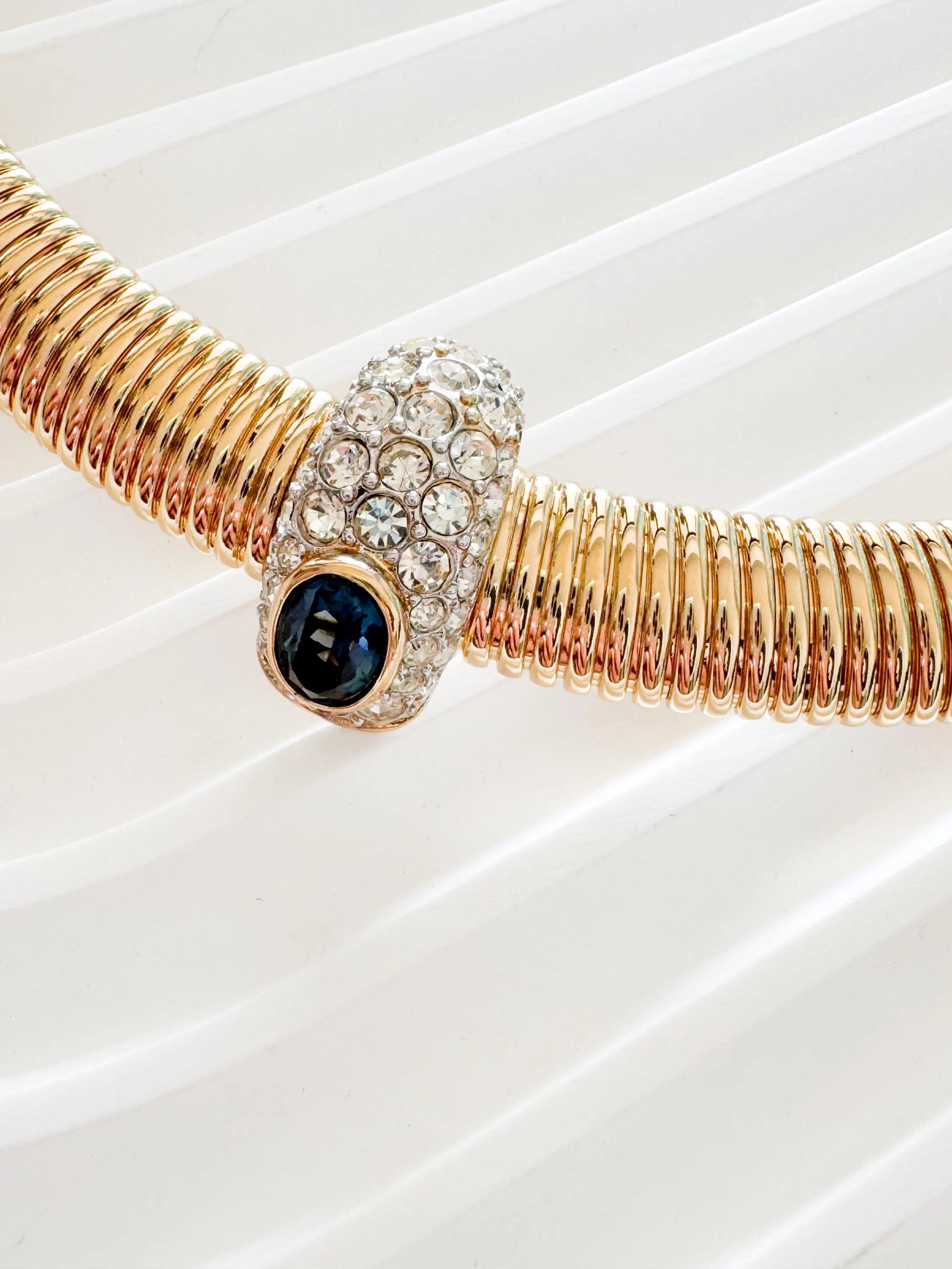 Vintage Nina Ricci Tubogas choker necklace in gold tone with sapphire-blue and clear crystals, elegant 1980s-style designer jewelry.