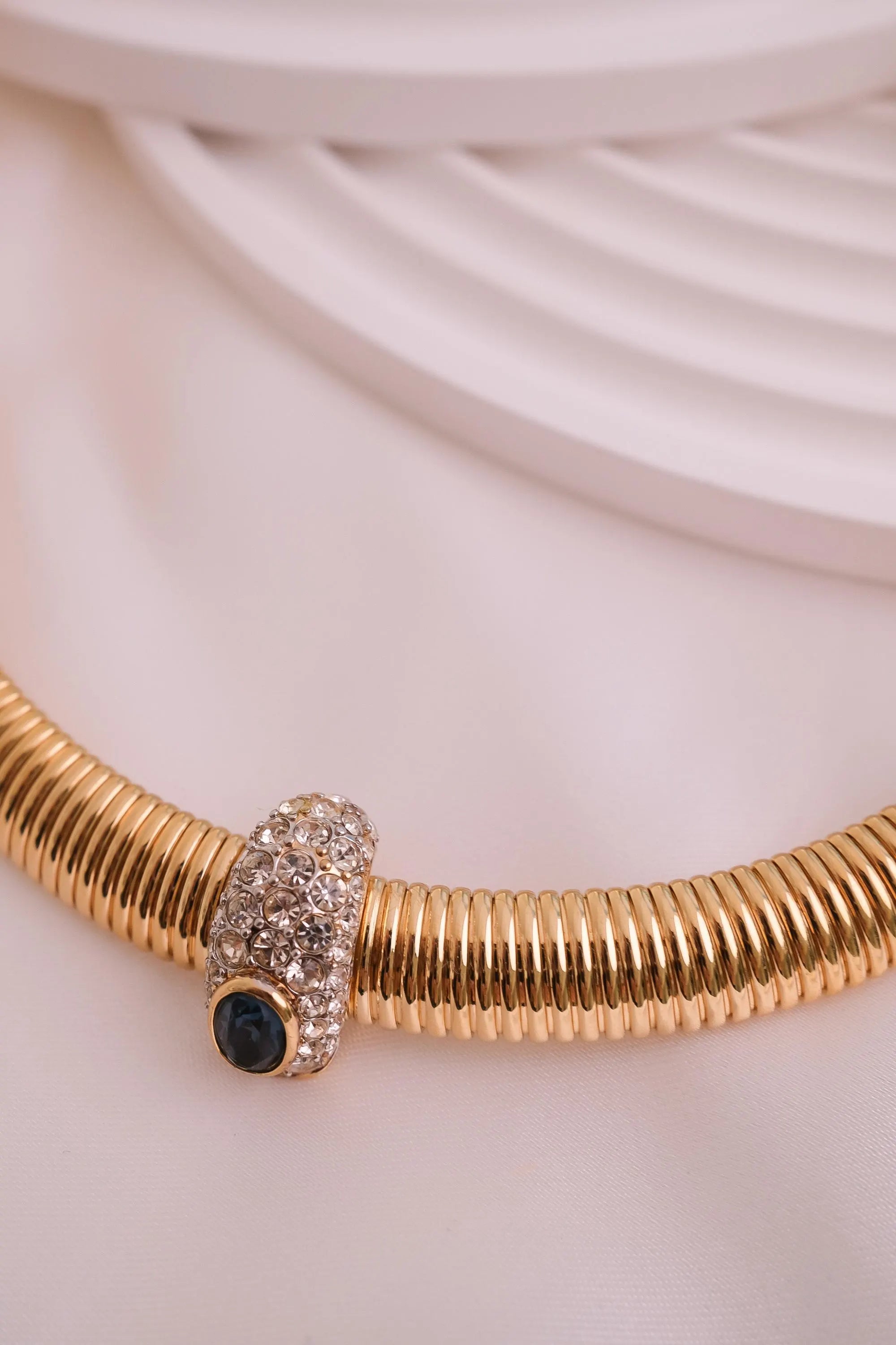 Vintage Nina Ricci Tubogas choker necklace in gold tone with sapphire-blue and clear crystals, elegant 1980s-style designer jewelry.
