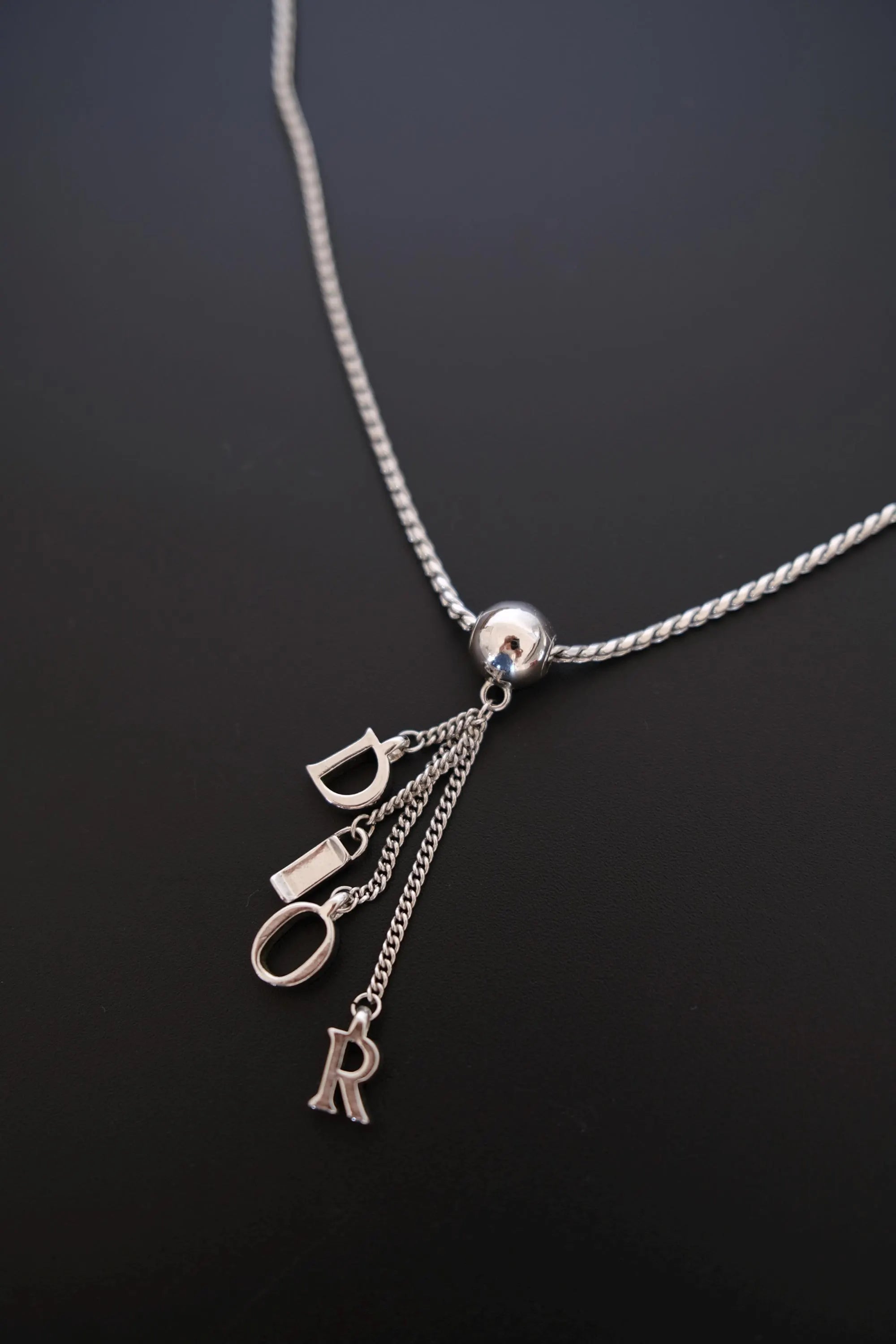 Vintage Dior polished spherical centerpiece and dangling letter tassel detail