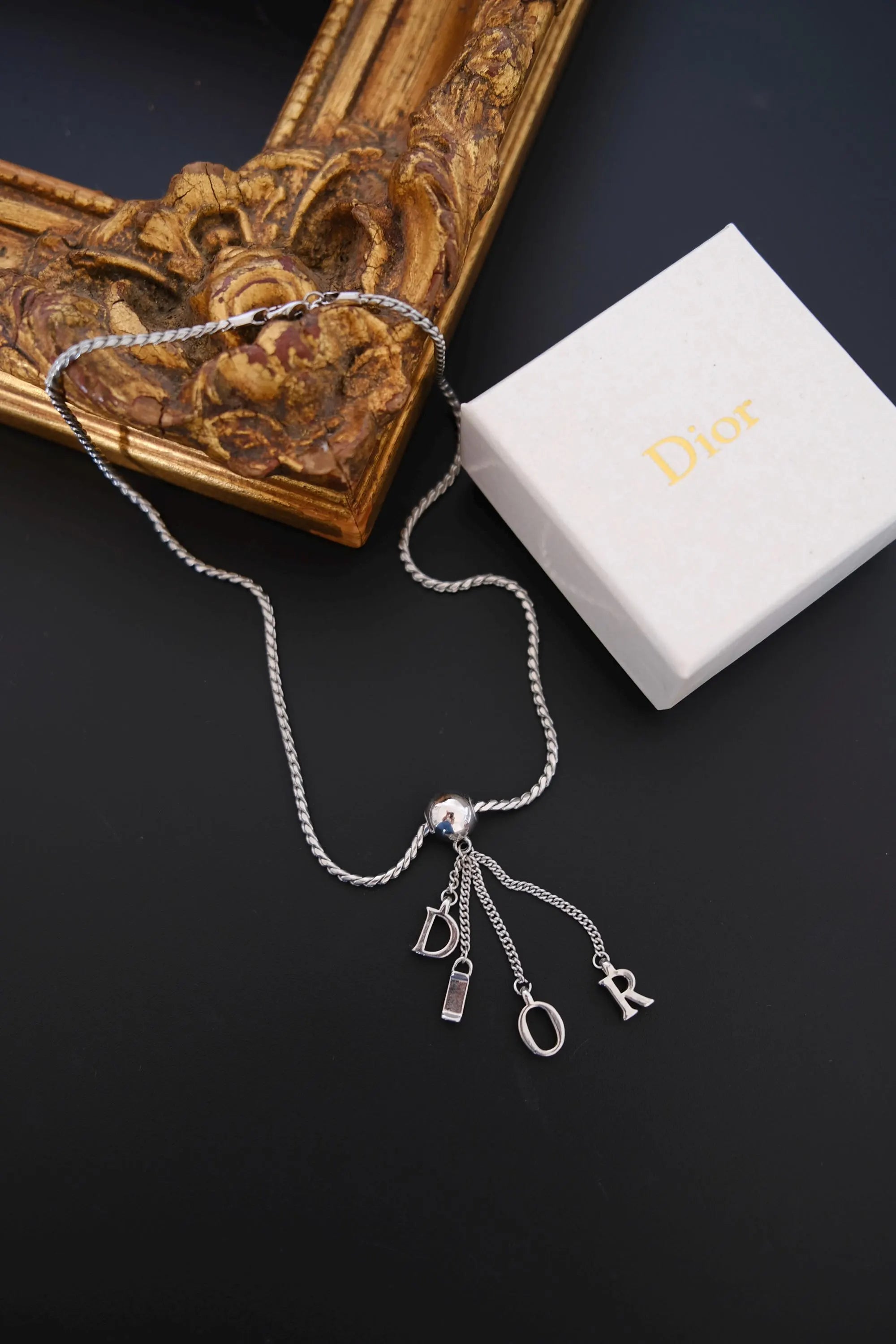 Vintage Christian Dior D-I-O-R letter charm necklace displayed with Dior box