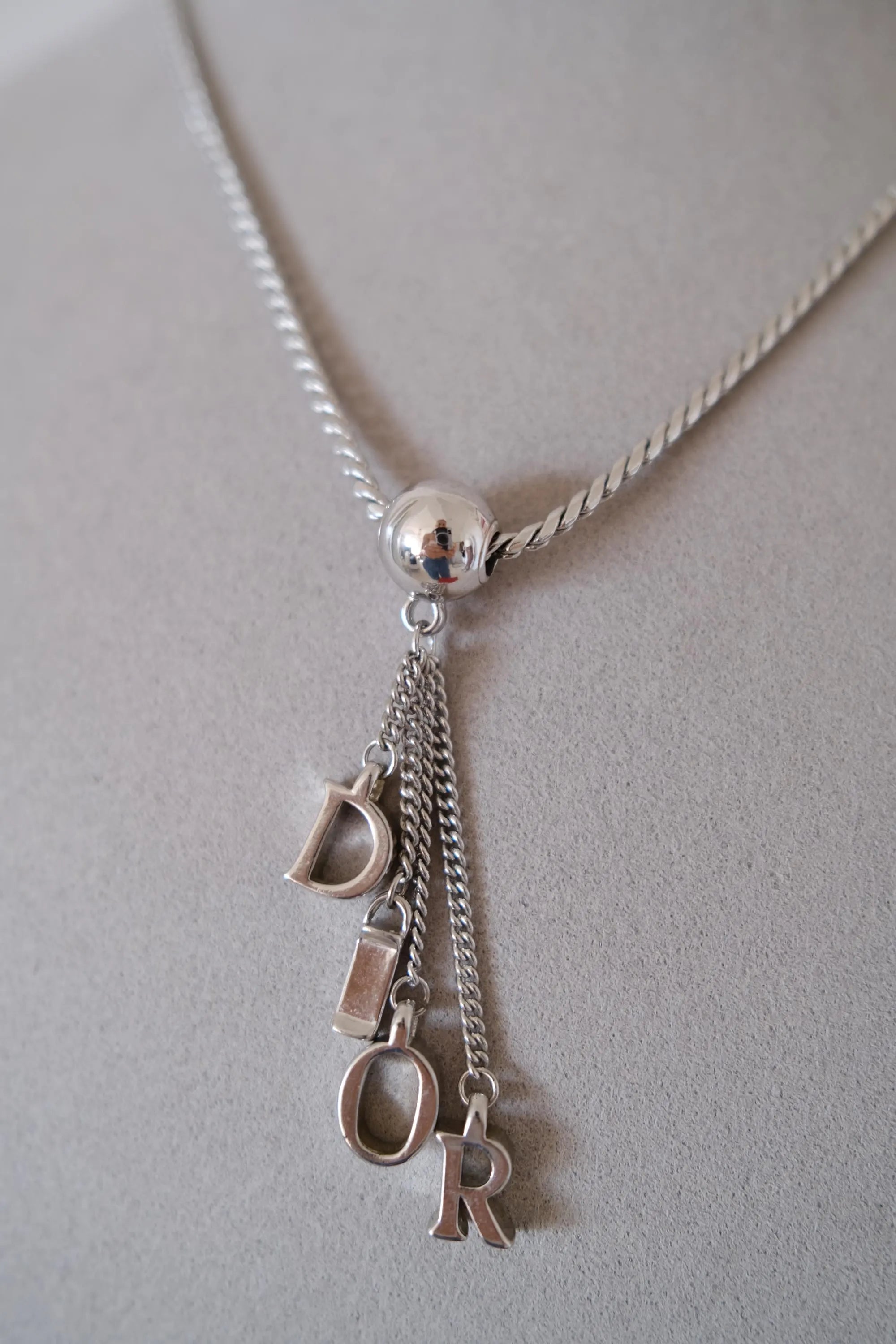 Vintage Christian Dior D-I-O-R dangling letter charms suspended from a polished silver-tone sphere