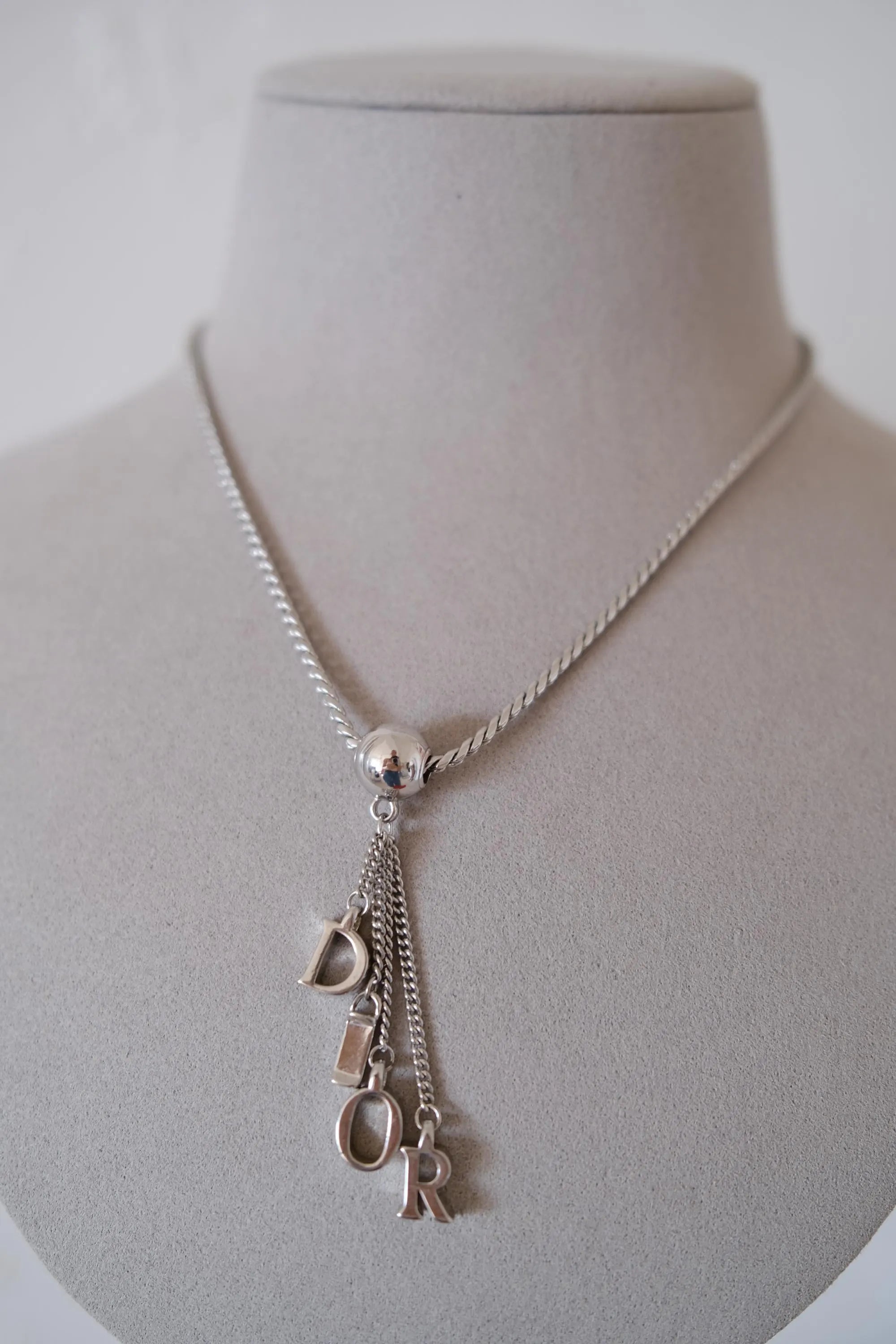Vintage Christian Dior D-I-O-R dangling letter charms suspended from a polished silver-tone sphere