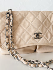 Vintage classic Chanel shoulder bag in caviar beige, made in France, with large front pockets, luxury designer handbag