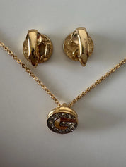 Close-up of Vintage Givenchy G logo crystal rhinestone necklace in gold tone