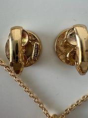 Close-up of Vintage Givenchy G logo crystal rhinestone earrings in gold tone