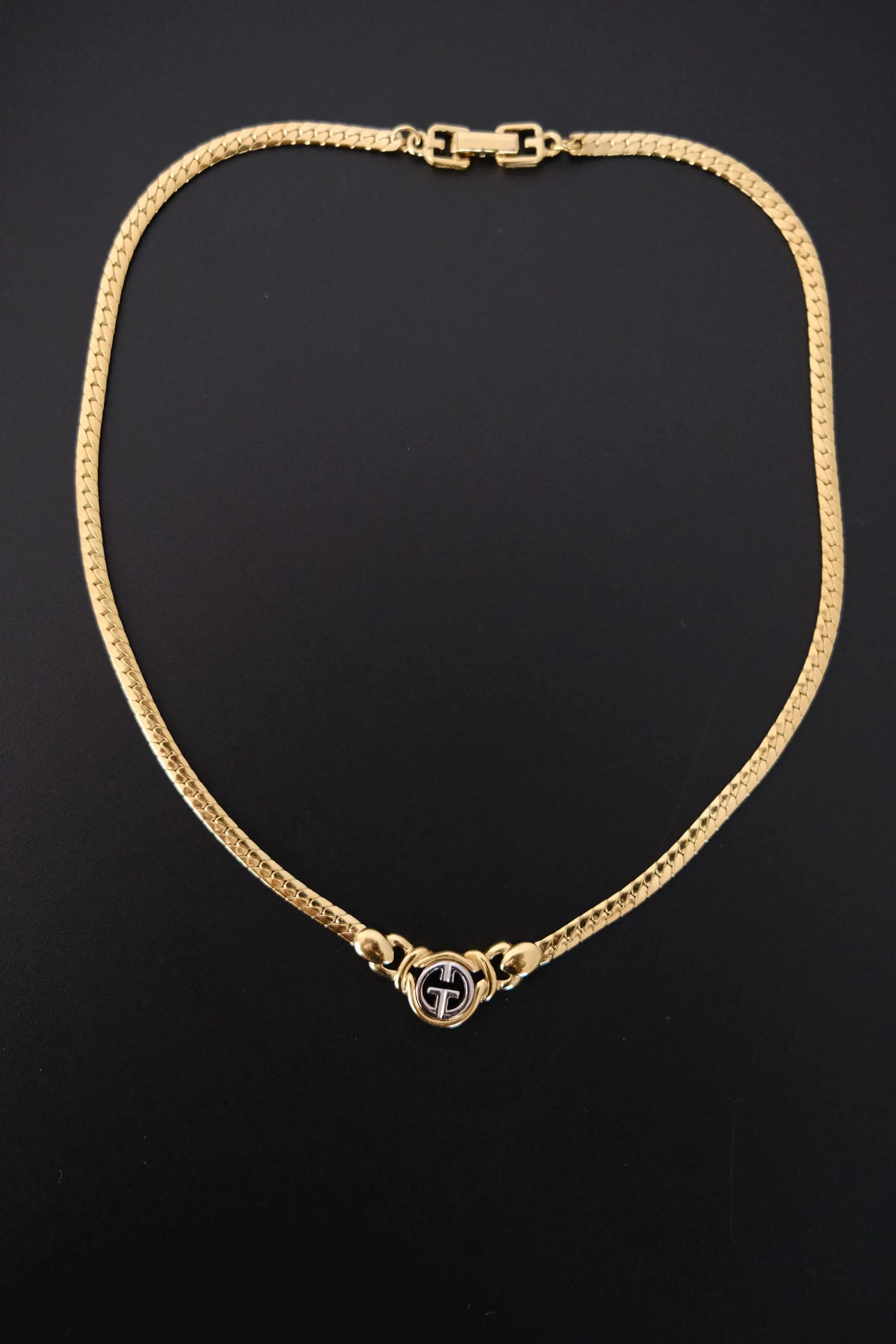 Vintage Givenchy gold-tone logo choker necklace worn at neckline