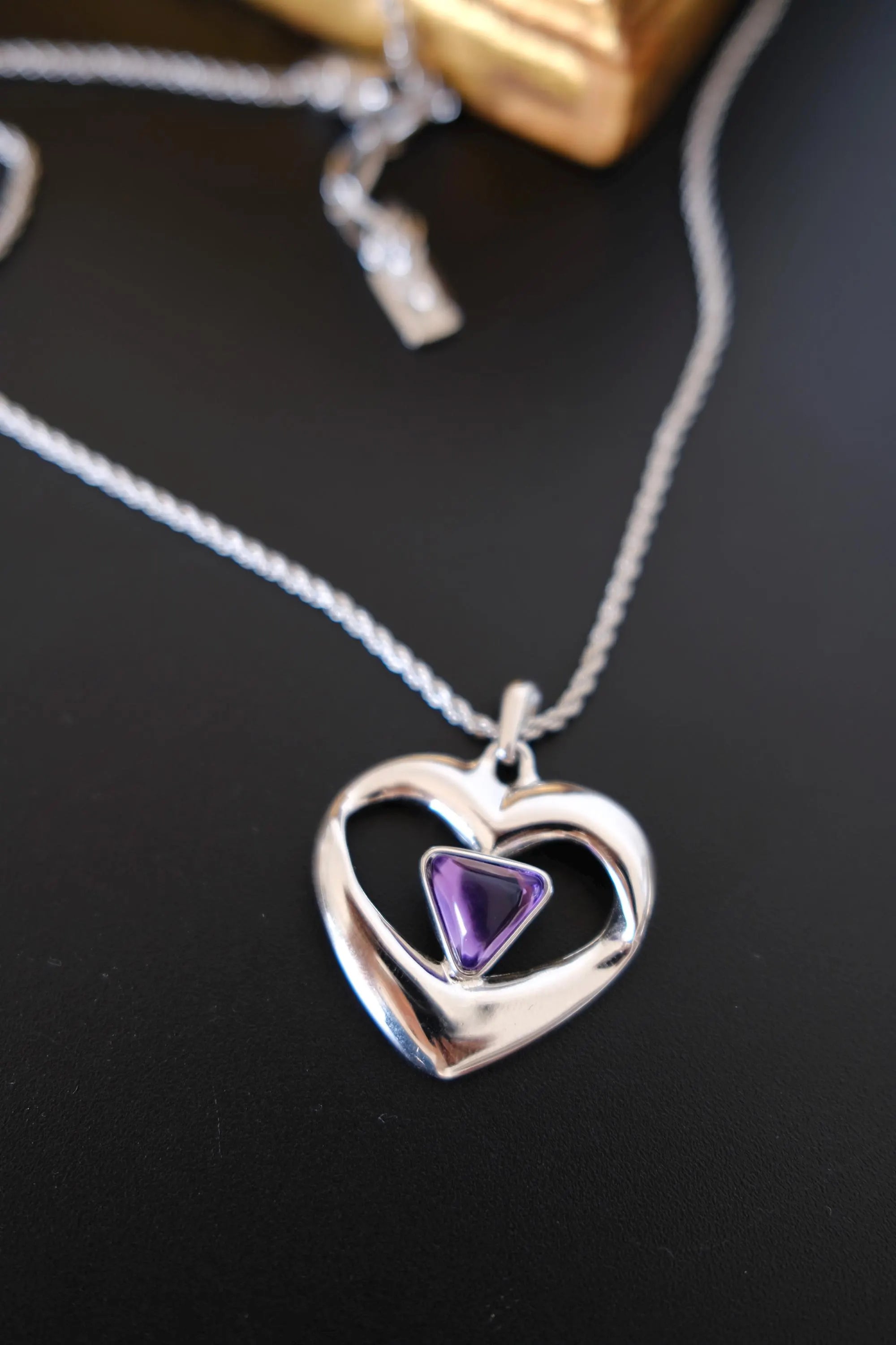 Vintage YSL silver-tone openwork heart pendant with triangular purple cabochon front view