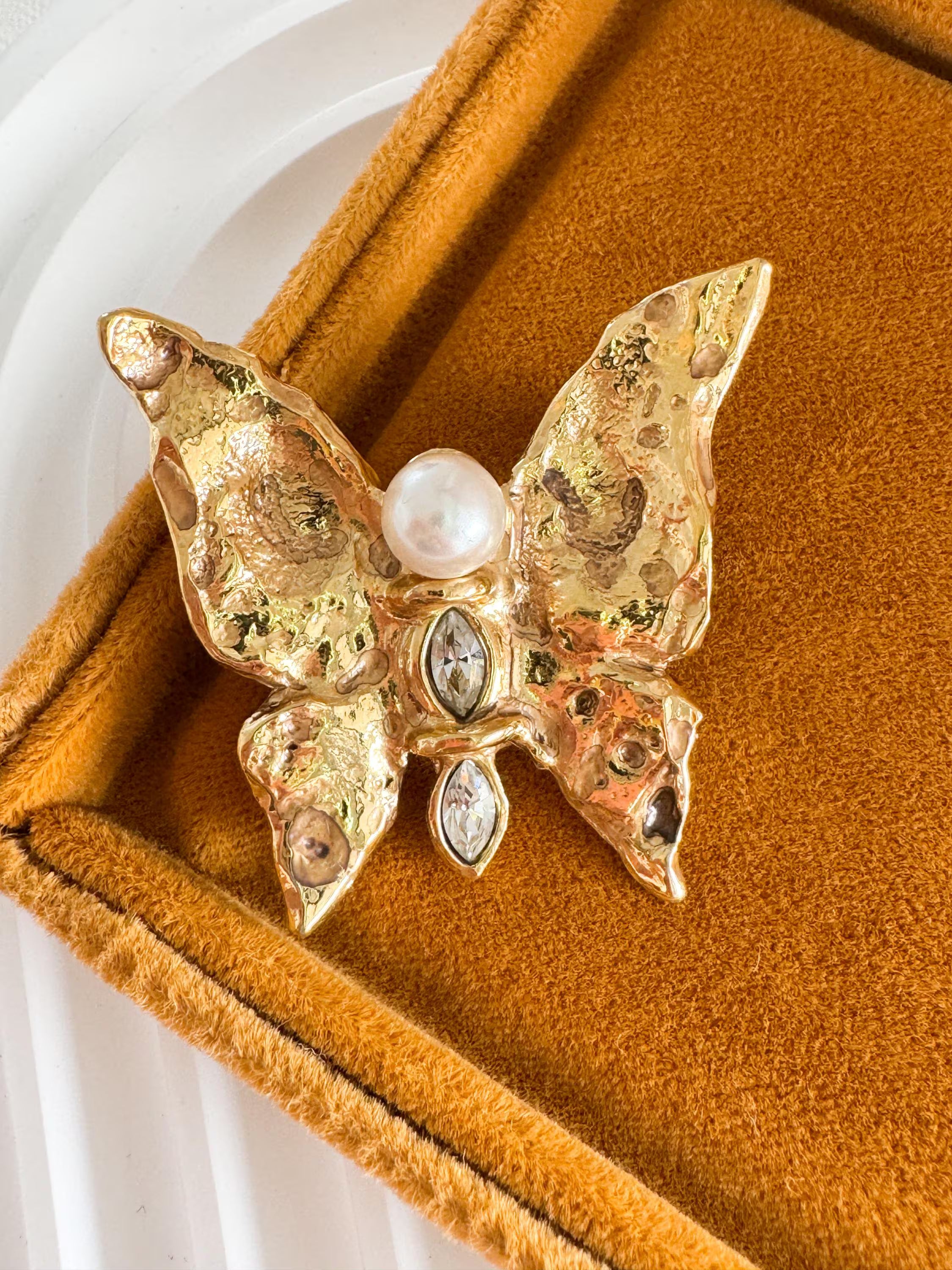 Vintage Yves Saint Laurent gold butterfly brooch with pearl and rhinestone accents, timeless couture elegance