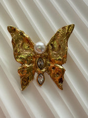 Vintage YSL gold butterfly pin with pearl and rhinestones, elegant and timeless designer accessory
