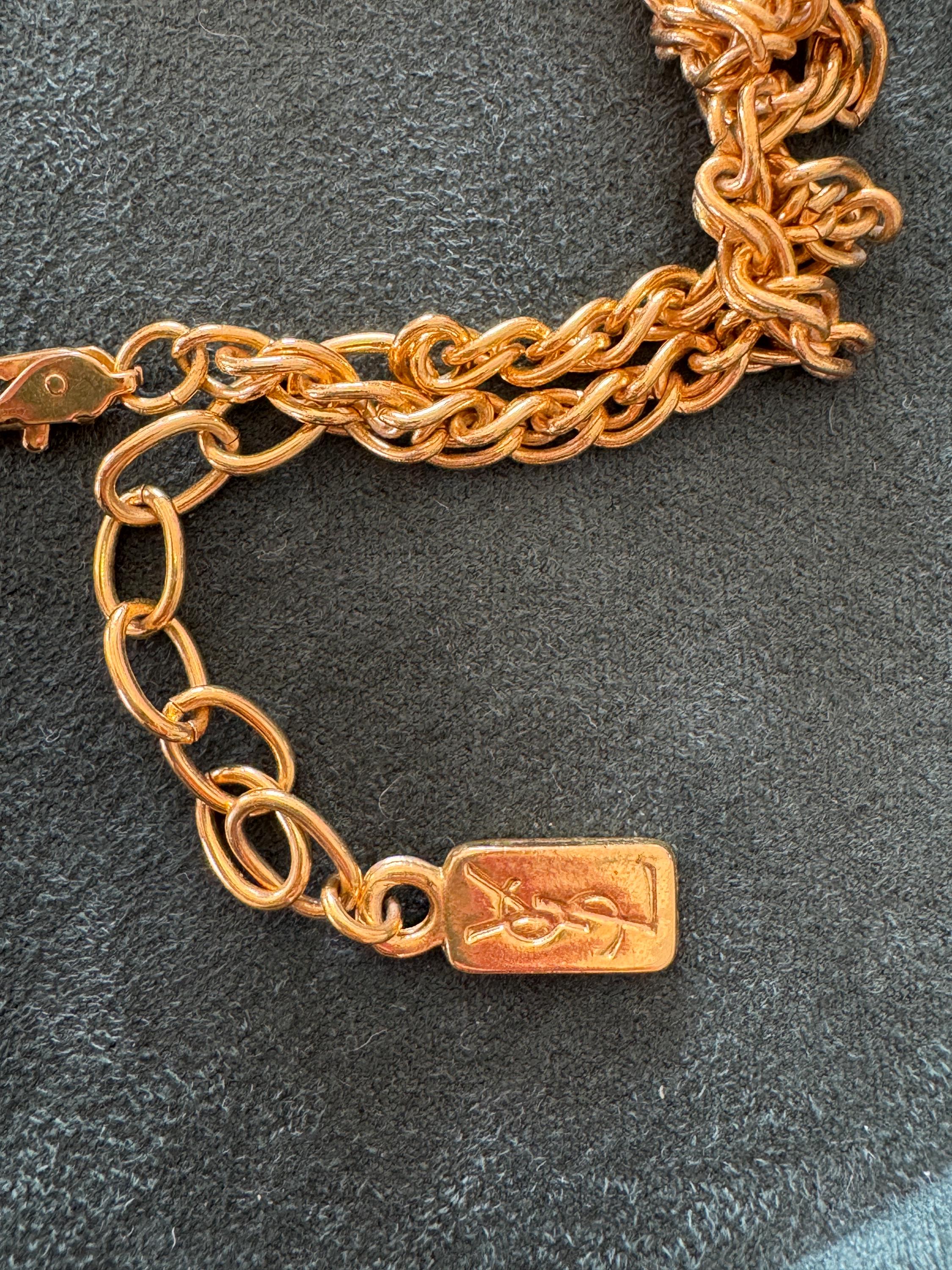 Close-up of YSL gold clover pendant with large faux pearl charm