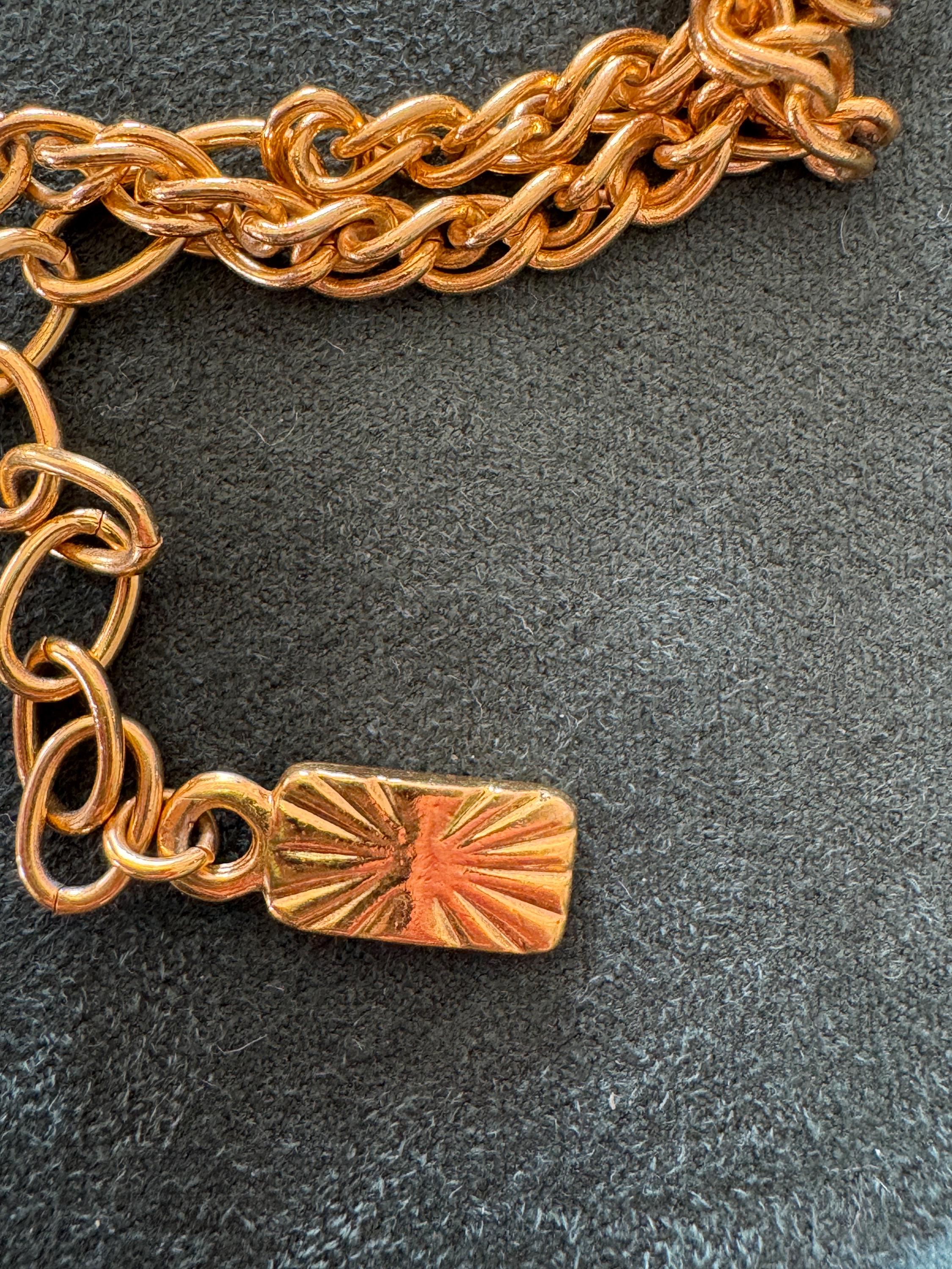 Close-up of YSL gold clover pendant with large faux pearl charm