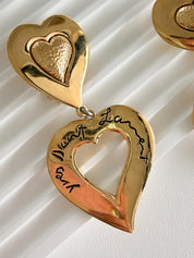 Close-up of engraved YSL heart detail on vintage gold dangle earrings