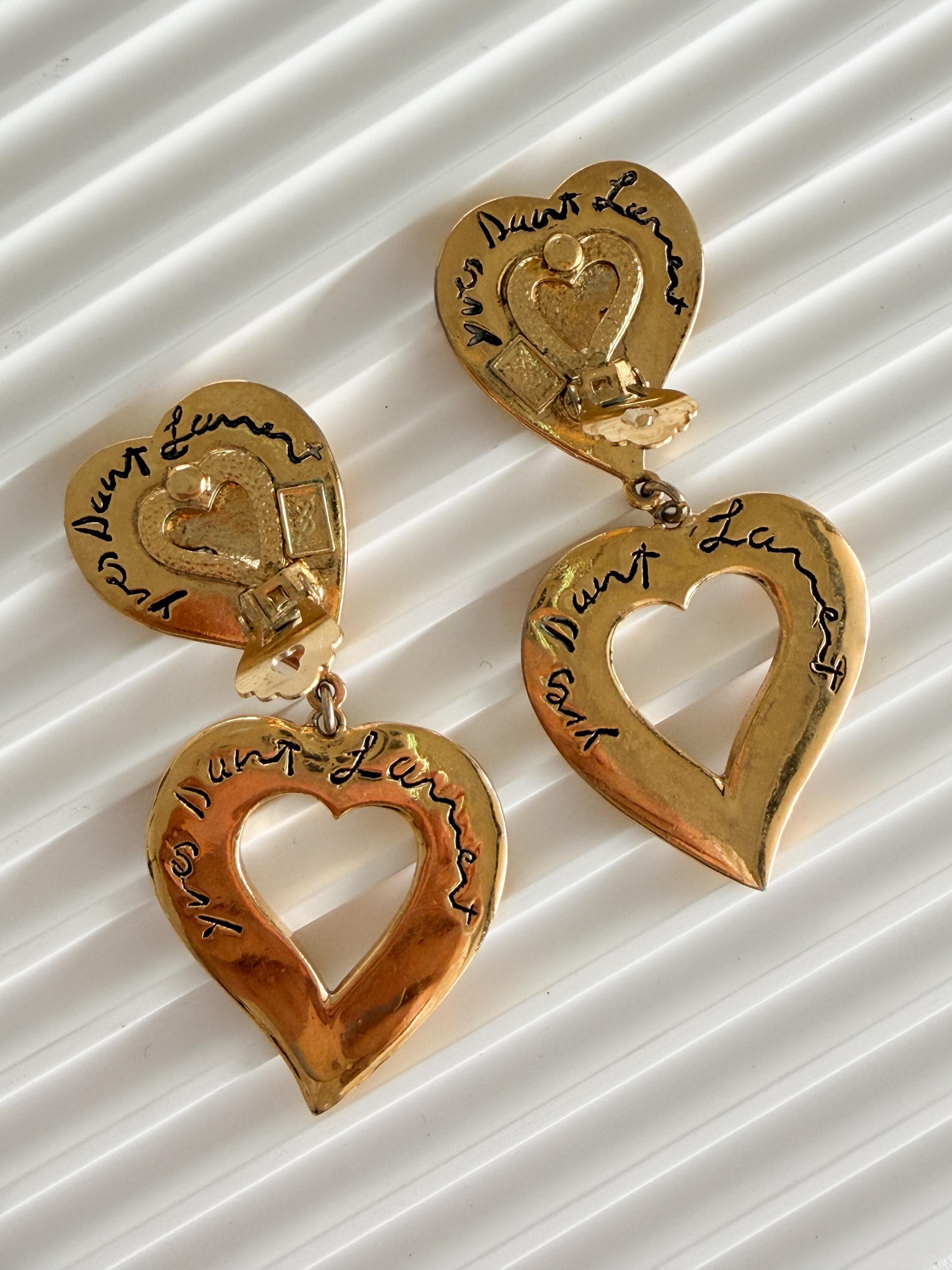 Close-up of engraved YSL heart detail on vintage gold dangle earrings