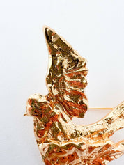 Close-up of vintage YSL dove bird brooch in gold tone