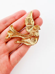 Close-up of vintage YSL dove bird brooch in gold tone