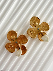 Close-up of sculptural flower design with polished center on vintage YSL earrings