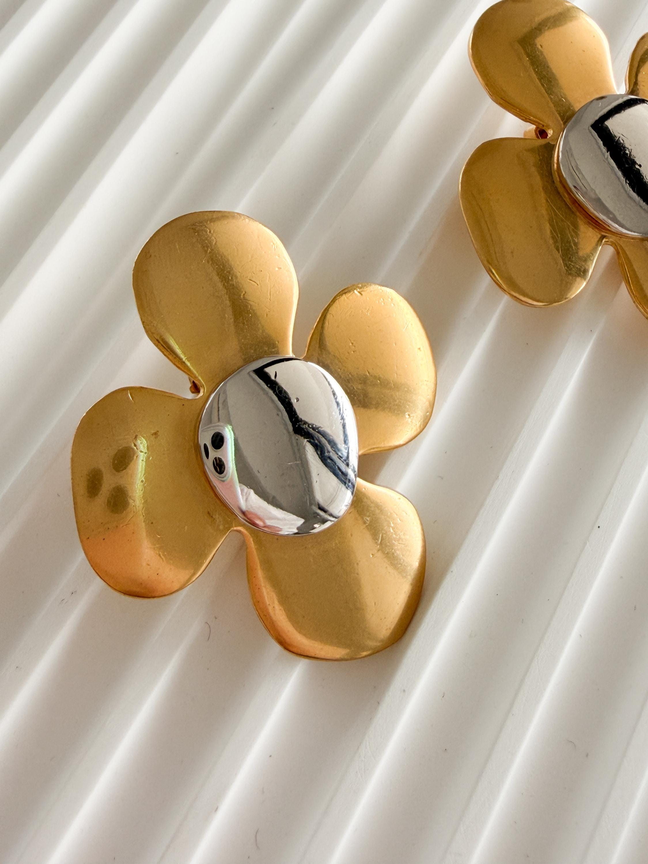 Close-up of sculptural flower design with polished center on vintage YSL earrings