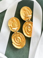 Close-up of Vintage YSL spiral clip-on dangle earrings in gold tone